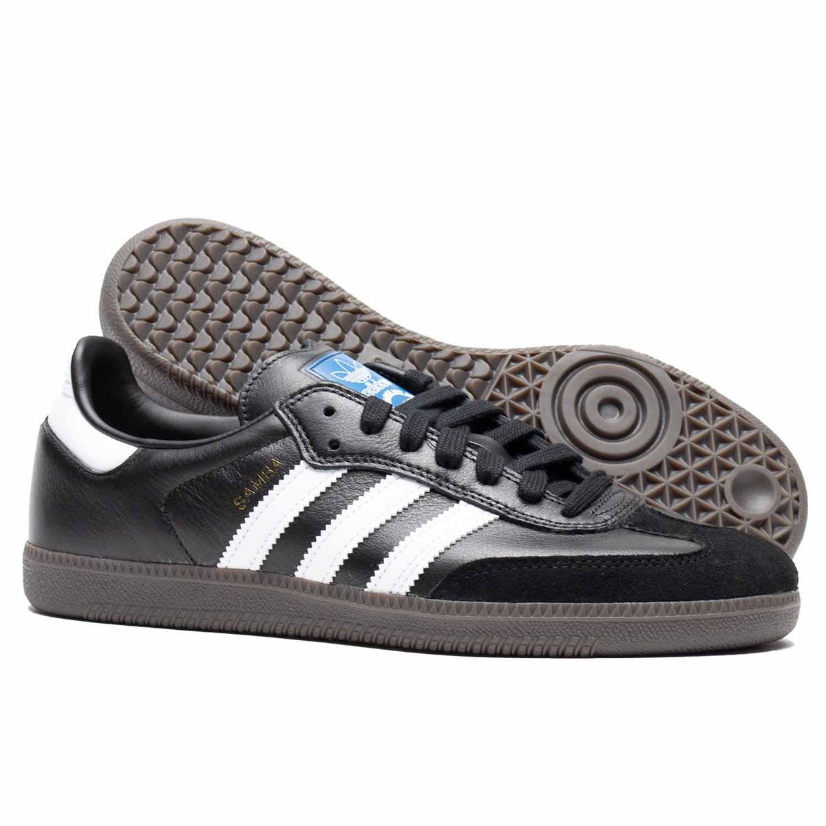 Black leather Adidas skateboarding shoe with white leather stripes and brown rubber sole. Suede toe cap.