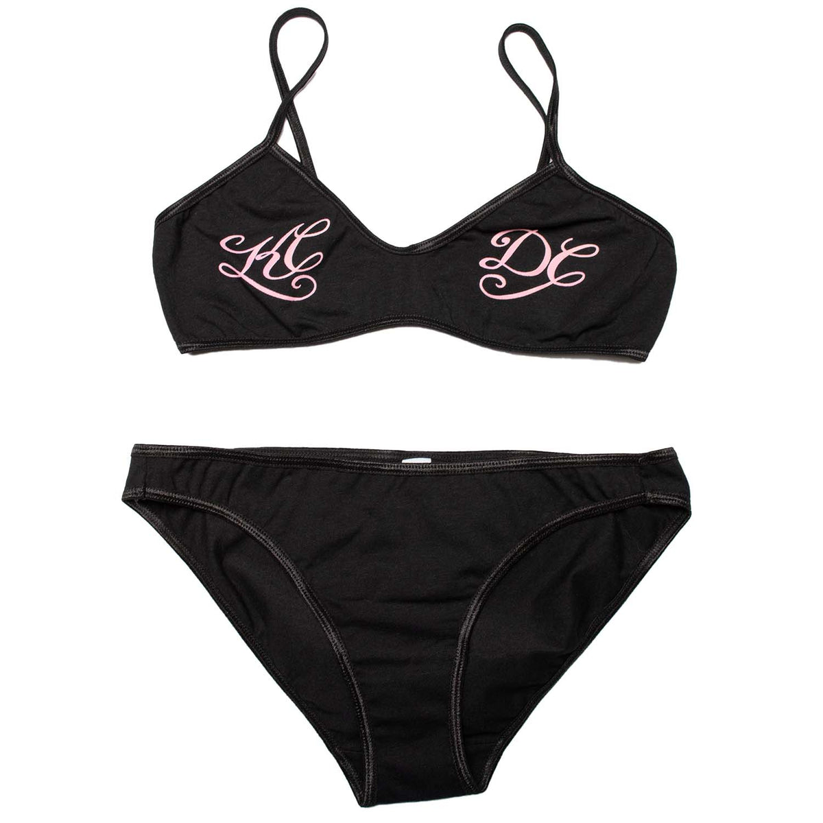 Black spandex spaghetti bralette with pink script printed, reading KC on the left breast, DC on the right breast. Pair with the KCDC bikini panty for the full set.