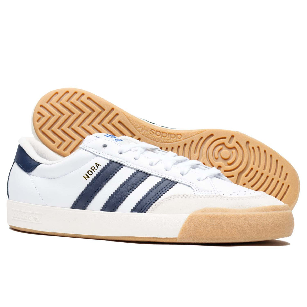 White leather Adias skateboarding shoe with navy leather detailing and cream colored toe cap with white and tan rubber.
