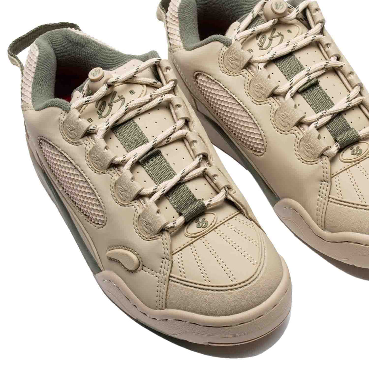 The Es Muska in tan and green, endorsed by Chad Muska, is the pinnacle of skateboarding footwear. Its PU cage and heel mesh offer durability, while the rubber toe cap and lace protection ensure longevity. Features like the hidden stash pocket, heel pull tab, and reflective logo on the heel add convenience and style. With a molded EVA footbed and 400 NBS rubber cupsole, it provides comfort and grip, ideal for skaters of all levels.