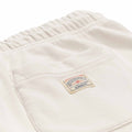 Polo Ralph Lauren x Element Sweatpants in cream with draw string and elastic in ankles. With back pocket on right side and small patch Polo Ralph Lauren x Element logo on pocket. Close up photo of patch with red and blue Polo Ralph Lauren x Element Logo.