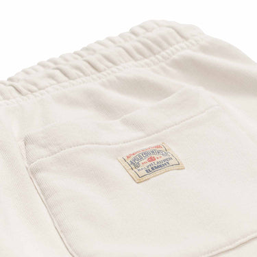 Polo Ralph Lauren x Element Sweatpants in cream with draw string and elastic in ankles. With back pocket on right side and small patch Polo Ralph Lauren x Element logo on pocket. Close up photo of patch with red and blue Polo Ralph Lauren x Element Logo.